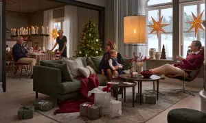 En familj njuter av julstämningen med julgran, presenter och levande ljus. Perfekt jul inredning inspiration för en mysig högtid.