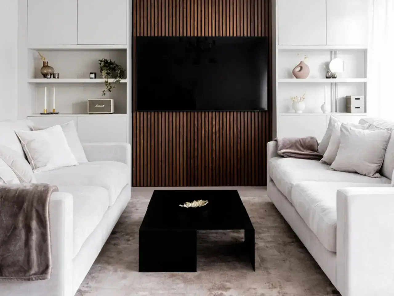 Modernt vardagsrum med två soffor, ett svart soffbord och en vägg med träpanel som ger panel inomhus inspiration.